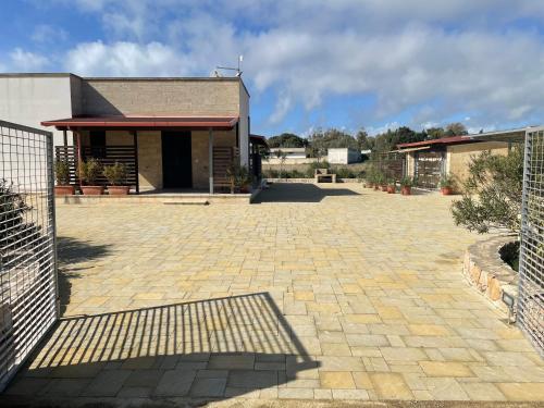 a building with a brick courtyard in front of it at Villetta La Lama in Torre Lapillo
