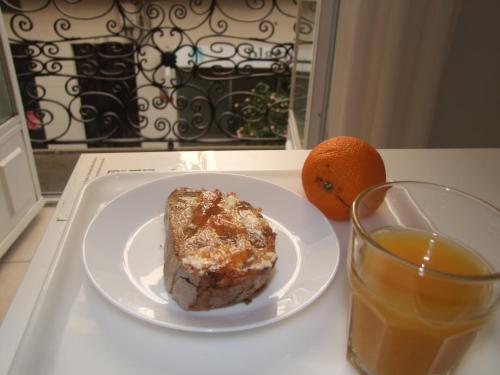 a plate with a piece of cake and a glass of orange juice at Real Ferrol in Ferrol
