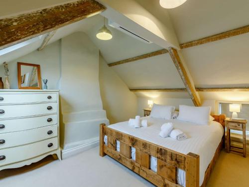 Glanton的住宿－2 Bed in Powburn 90310，一间卧室配有一张带白色床单的床和梳妆台。