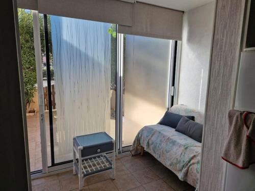 une chambre avec un lit et une grande fenêtre dans l'établissement Agréable appartement 3 Personnes Port La Nouvelle RDC et petit jardin, à Port-la-Nouvelle