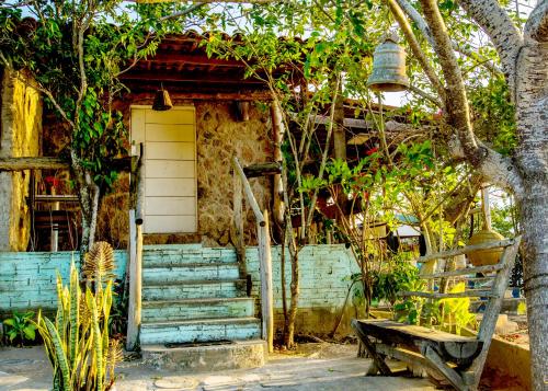 stary dom z ławką przed nim w obiekcie Paradise Camp w mieście Monte das Gameleiras