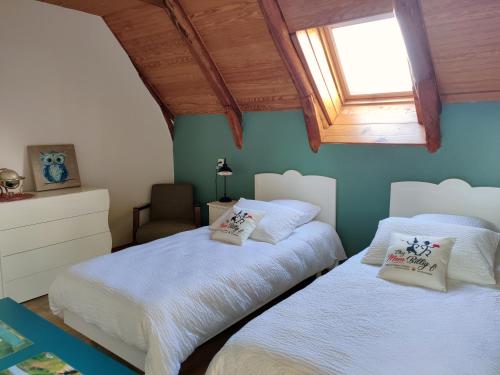 2 camas en un dormitorio con ventana en Maison d'Hôtes à Saint Nectaire Chez MamBillig en Saint-Nectaire