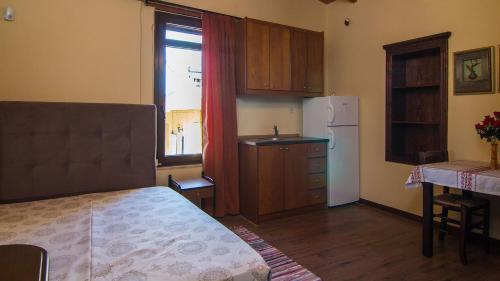 a room with a kitchen with a bed and a refrigerator at villa Morfeas in Dhamavólos
