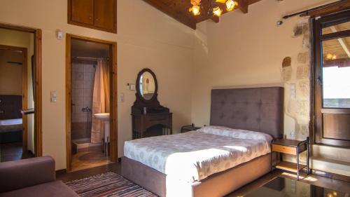 1 dormitorio con cama y espejo en villa Morfeas en Dhamavólos