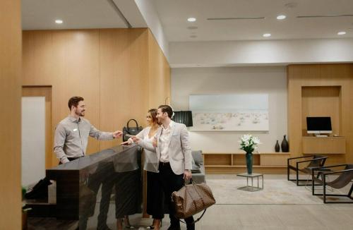 a group of three people standing next to a piano at Level Los Angeles - Downtown South Olive in Los Angeles