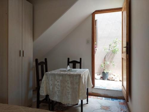 einen Tisch und Stühle in einem Zimmer mit Fenster in der Unterkunft MELMAR - Habitación triple con baño privado in Godoy Cruz