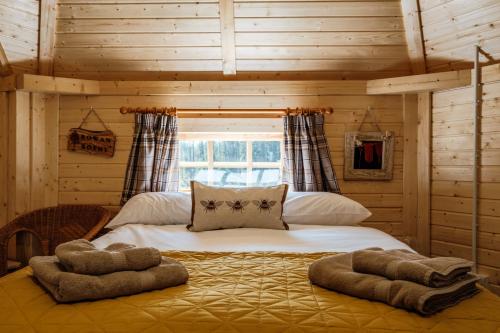 a bedroom with a large bed in a log cabin at Cairngorm Bothies in Aboyne
