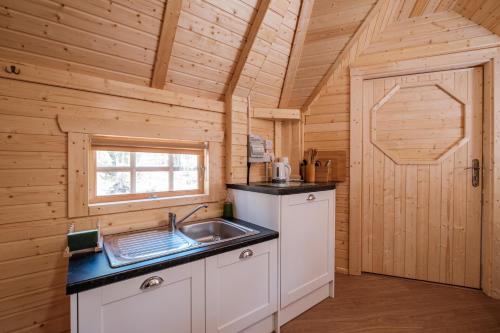 a kitchen with a sink in a wooden cabin at Cairngorm Bothies in Aboyne