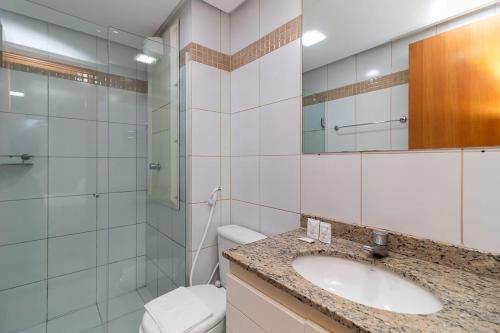 Un baño con lavabo, inodoro y espejo. en Depto frente Lago Paranoá - CLR314, en Brasilia