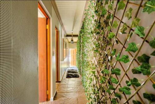 a hallway with a wall covered in plants at iShoba Retreat in Centurion