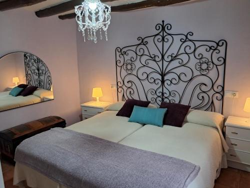 a bedroom with two beds and a chandelier at Ruta del Agua Casa Completa 4 hab al lado Monasterio de Piedra in Munébrega