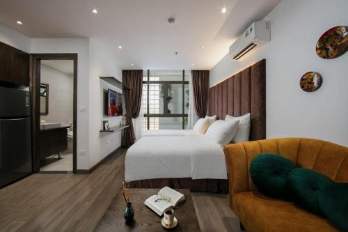 a hotel room with a bed and a couch at The Bloom Hanoi - Bespoke Living in Hanoi