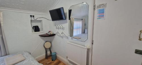a room with a mirror and a bed and a tv at Happi Hotel and Spa in Blackpool