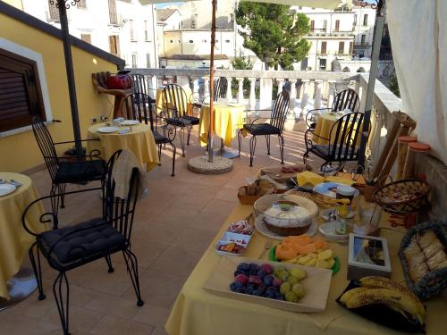 a table with food on a balcony with tables and chairs at Sei Stelle in Sulmona