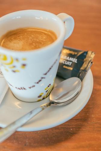 a cup of coffee on a plate with a spoon at Hotel Duc de Vendôme in Vinaròs