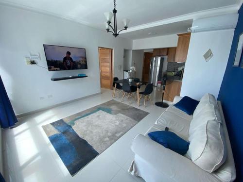 a living room with a white couch and a tv at Peaceful and Cozy Condo in Costa Verde in Santo Domingo