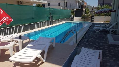 a swimming pool with two lounge chairs and a swimming pool at A flat with two rooms close the Lara Beaches d12 in Altınkum