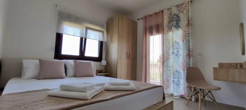 a bedroom with a bed with towels on it at Scenic Kriopigi Getaway - Cozy Anna-Maria Apartment for 4 in Kriopigi