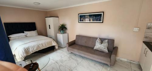 1 dormitorio pequeño con 1 cama y 1 sofá en Batchelor at Labiance by Cozy en Ciudad del Cabo
