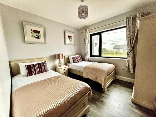 a bedroom with two beds and a window at Portmagee Paradise in Portmagee