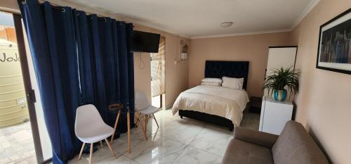 1 dormitorio con 1 cama y 1 sofá en Batchelor at Labiance by Cozy en Ciudad del Cabo