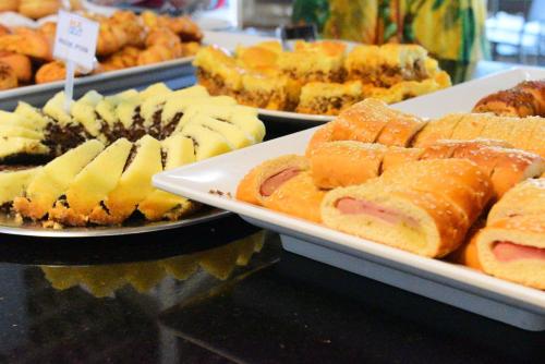 a buffet of different types of pastries on plates at Resort do Lago Oficial in Caldas Novas
