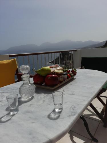 a table with a tray of fruit and glasses on it at Mirabello Sea House in Agios Nikolaos