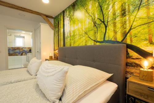 - une chambre avec une fresque murale sur les arbres dans l'établissement Pfeffer's kleine Ferienwohnung, à Bad Lauterberg