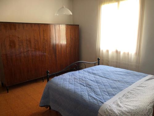 una camera da letto con un letto, un comò e una finestra di Casa Natalina a Casal Fiumanese