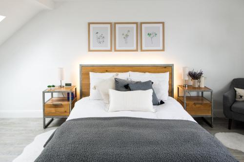 a bedroom with a large white bed with pillows at Contemporary 5 Bedroom with Garden North Finchley in London