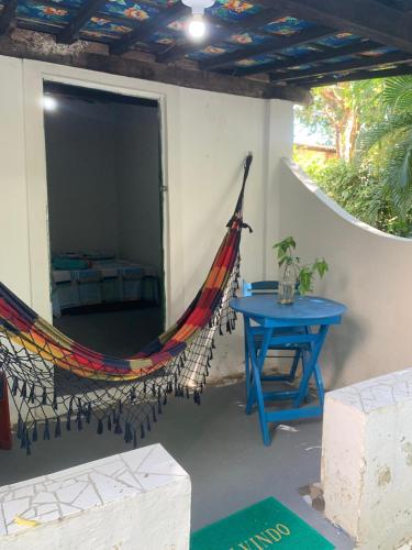 een hangmat aan de zijkant van een huis met een tafel bij Despertamar- Hospedagem em Calhetas in Cabo de Santo Agostinho