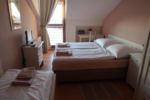 a bedroom with two beds and a desk and a window at Penzion Jízdárna Suchá in Litomyšl
