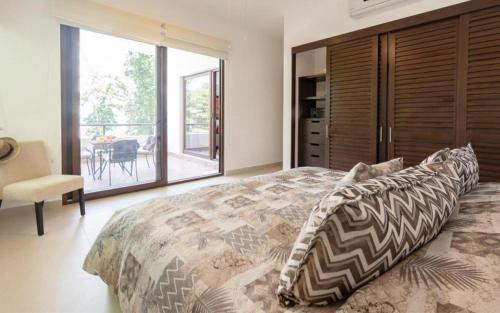 Un dormitorio con una cama grande y un balcón. en Caribbean Golf and Beach Retreat, en Akumal