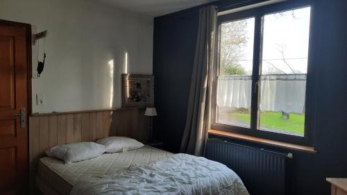 une chambre avec un lit et une fenêtre dans l'établissement maison en campagne proche circuit des 24 h du Mans, à Allonnes