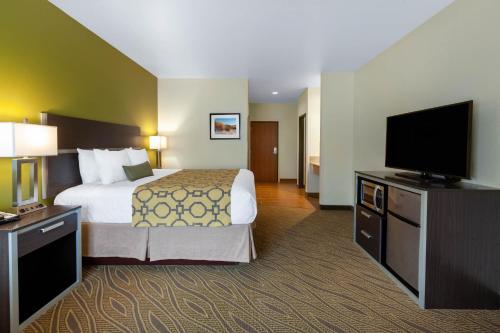 a hotel room with a bed and a flat screen tv at Baymont by Wyndham Beulah in Beulah