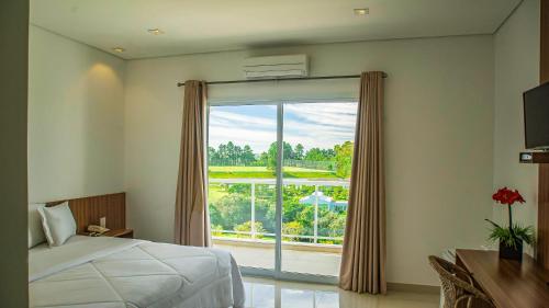 a bedroom with a bed and a large window at Otho Hotel Convention & SPA in Itu