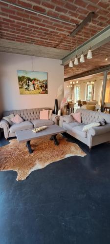 - un salon avec des canapés blancs et un tapis dans l'établissement B&B Euverbraeke, à Beveren