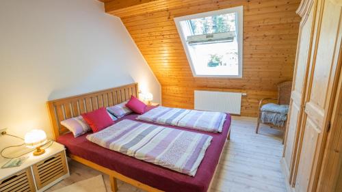 een slaapkamer met een bed in een kamer met een raam bij Schwarzwaldferienwohnung Oberle in Todtnau