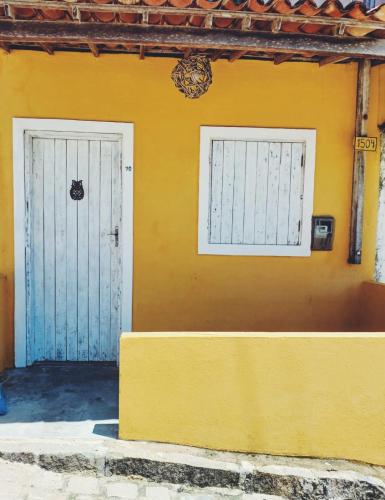 zwei Türen an der Seite eines gelben Gebäudes in der Unterkunft Casa do Sol in Pipa