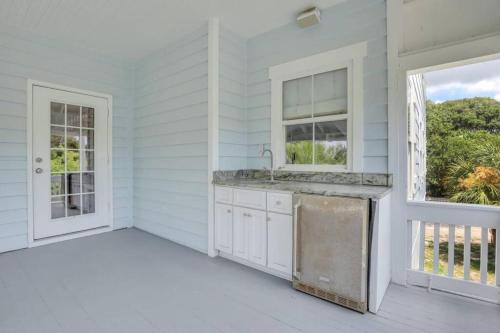 eine weiße Küche mit Spüle und Fenster in der Unterkunft Luxury Beach Front Home: Breath Taking Views in Tybee Island