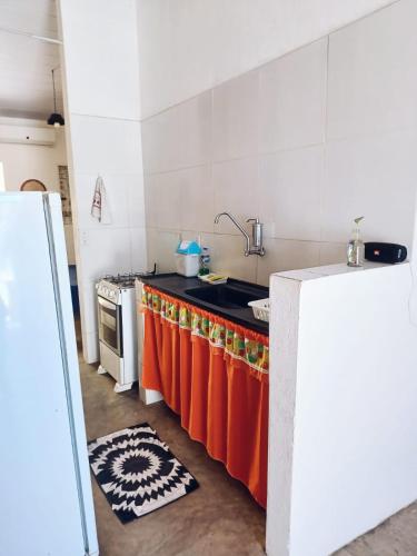 eine Küche mit einer orangefarbenen Theke und einem Waschbecken in der Unterkunft Casa do Sol in Pipa