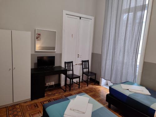 a room with two beds and a desk and a computer at Guesthouse La Briosa Nicole in Genova