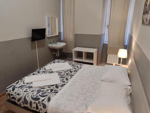 a small bedroom with a bed and a sink at Guesthouse La Briosa Nicole in Genova