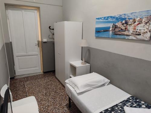 a small room with two beds and a refrigerator at Guesthouse La Briosa Nicole in Genova