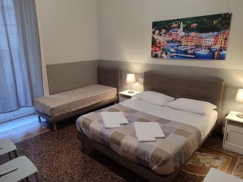 a hotel room with a bed and a bed and a table at Guesthouse La Briosa Nicole in Genova