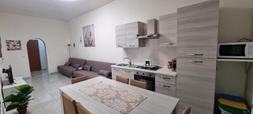 a kitchen and living room with a table and a couch at Appartamento centro Niscemi 2 in Niscemi