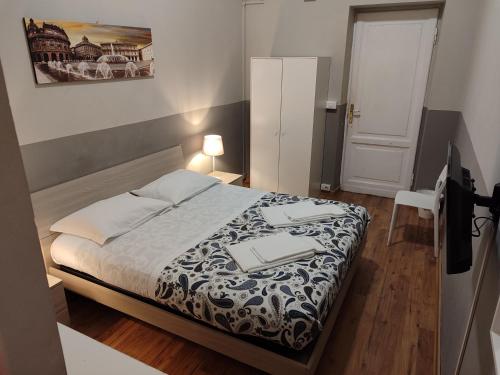 a bedroom with a bed and a table and a lamp at Guesthouse La Briosa Nicole in Genoa