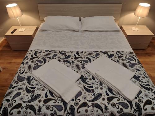 a bedroom with a bed with two nightstands and two lamps at Guesthouse La Briosa Nicole in Genova