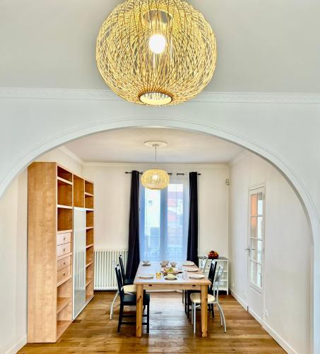une salle à manger avec une table et un lustre dans l'établissement Maison Disney Paris 7 pers Jardin Privé JO24, à Vaires-sur-Marne