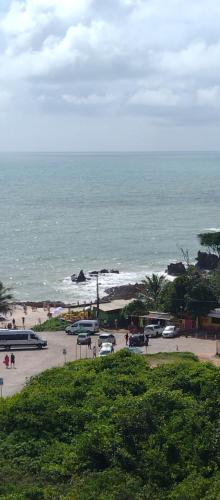 a beach with cars parked in a parking lot next to the ocean at Apartamento com vista para o mar in Conde